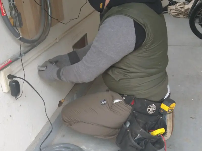 Electrician performing outlet wiring in a Rosemount garage
